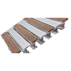 Rigid recessed aluminum entrance grate seated flush in a deep floor pit